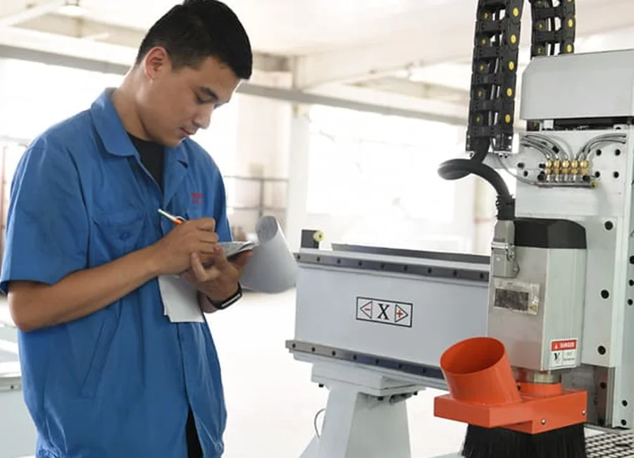 Quick CNC technician checking tooling near a CNC router spindle